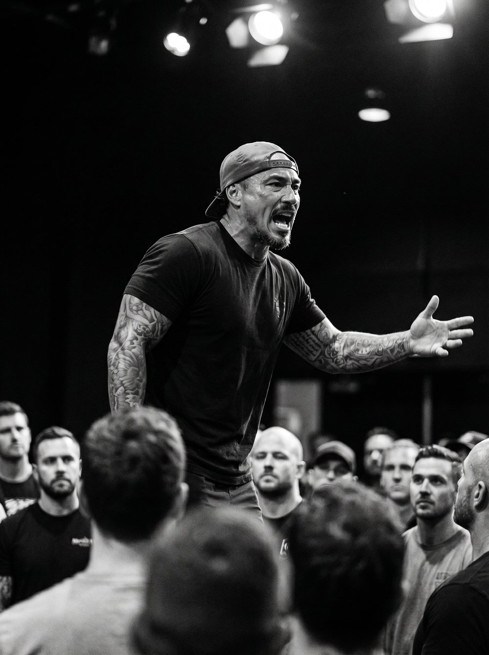 Kevin on stage speaking to a room of men